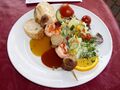 „Ruhrpott meets Sylt“ Currywurst-Scampi-Spiess auf Curry- und Mangosauce an sommerlichen Blattsalaten dazu Baguettebrot